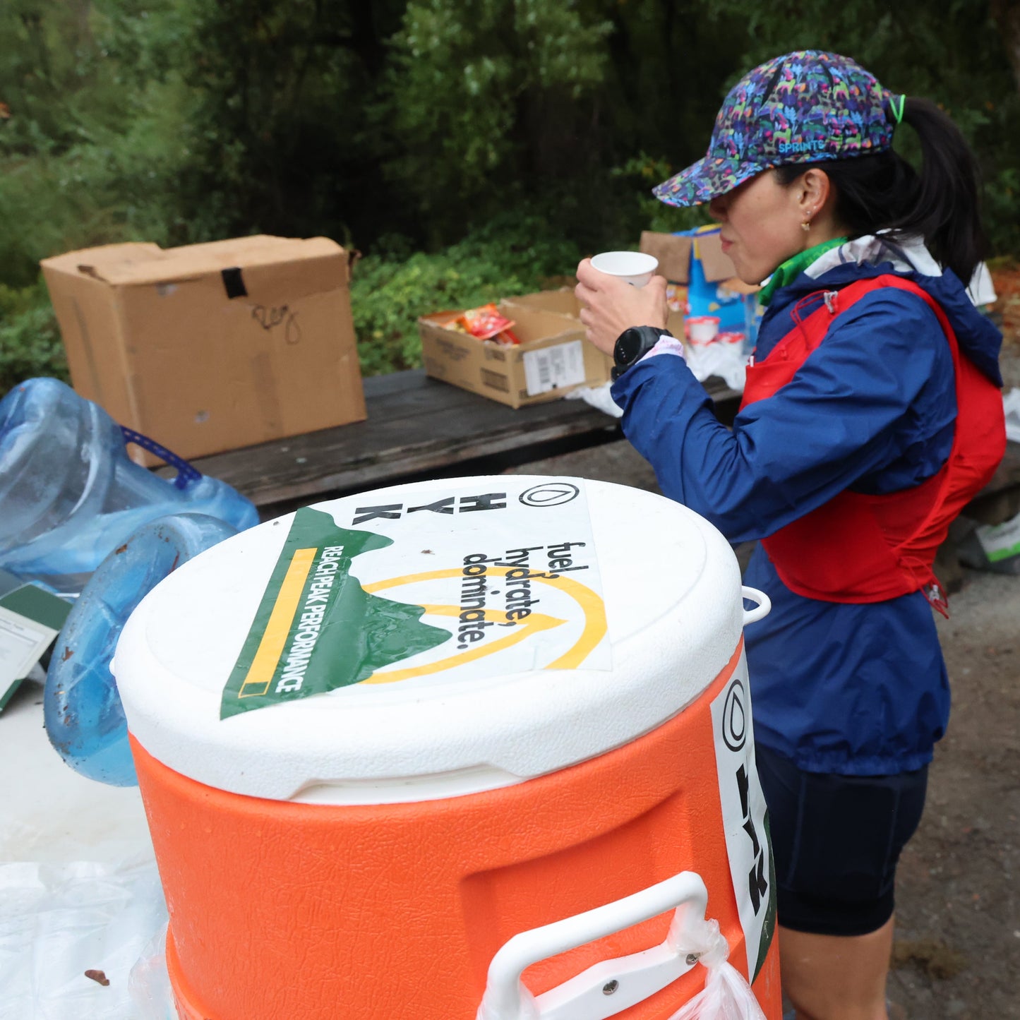 Female rail runner drinking HYK at aid station